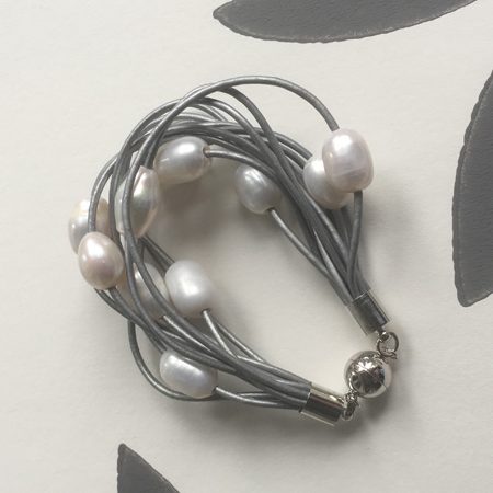 A grey leather pearl bracelet with 10 strands of shimmering grey leather.