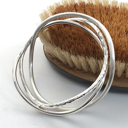 stacked curved silver bangles