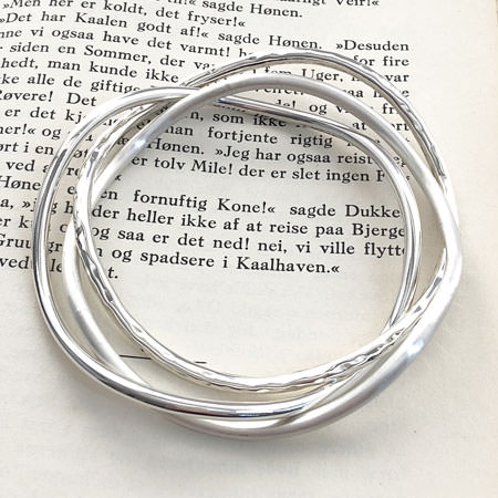 three curved silver bangles